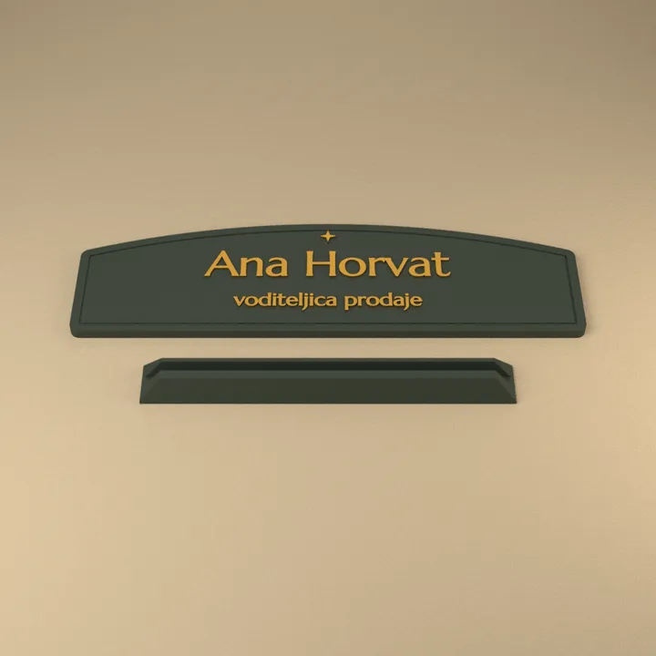 Tamnozelena stolna ploča sa zlatnim natpisom Ana Horvat, voditeljica prodaje, i podnožje